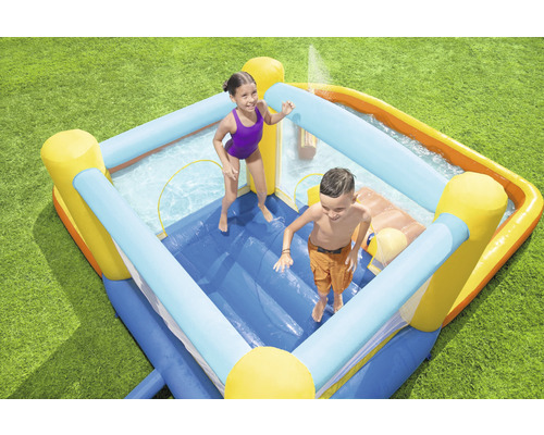 Aufblasbare Hüpfburg mit Planschbecken und zwei Kindern im Garten.