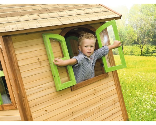 Kind schaut aus Fenster eines Holzspielhauses