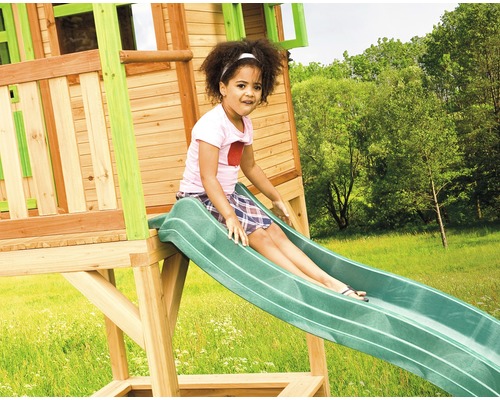 Mädchen rutscht auf einer Spielturm Rutsche im Garten