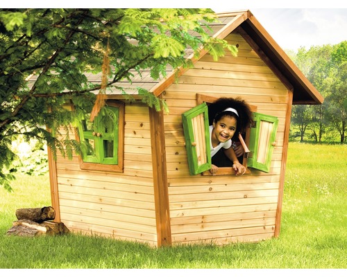 Kind schaut aus Fenster eines Holzspielhauses im Garten.