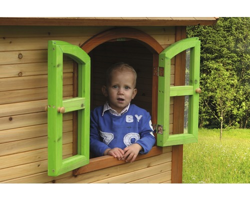 Kind schaut aus dem Fenster eines Holzspielhauses