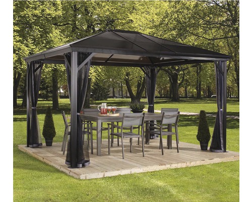 Pavillon SOJAG Verona 10x14 mit Moskitonetz 413 x 288 cm anthrazit Gartenpavillon mit Vorhängen, Tisch und Stühlen auf einer Holzterrasse im Garten.