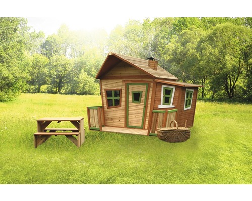 Spielhaus aus Holz mit Picknicktisch und Picknickkorb auf einer Wiese
