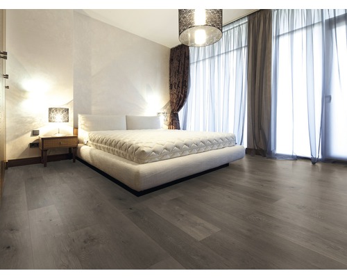 Schlafzimmer mit großem Bett, Nachttisch und Holzboden