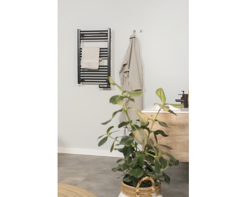 Modernes Badezimmer mit Handtuchheizkörper, Bademantel und Pflanze