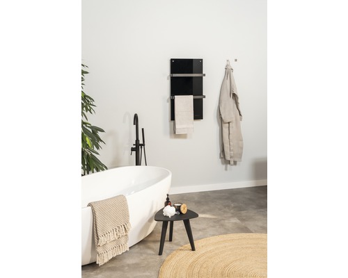 Badezimmer mit Badewanne, Hocker und Handtuchwärmer an der Wand