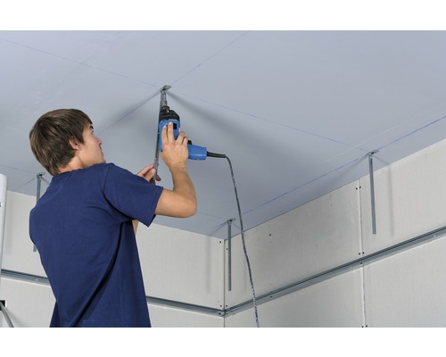 Mann montiert eine Deckenverkleidung mit einer Bohrmaschine an einer Metallunterkonstruktion.