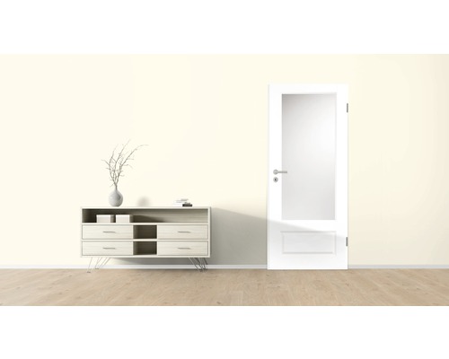 Heller Raum mit Kommode, Dekoration und Innentür mit Glaseinsatz.