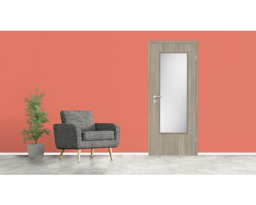 Zimmertür aus Holz mit Glaseinsatz, Sessel und Topfpflanze vor einer Wand