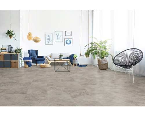 Helles Wohnzimmer mit Bodenbelag in Steinoptik, Sofa und Sessel