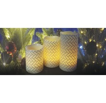 Drei dekorative LED Kerzen mit Ziegelmuster vor einem Weihnachtsbaum
