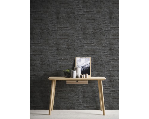 Zimmer mit dunkler Tapete mit horizontalem Muster und hellem Holztisch