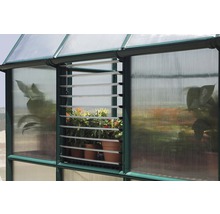 Detailansicht eines Gewächshauses mit Lamellenfenster und Pflanzen