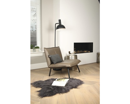 Wohnzimmer mit Sessel, Stehlampe, Kamin und Teppich auf Holzboden