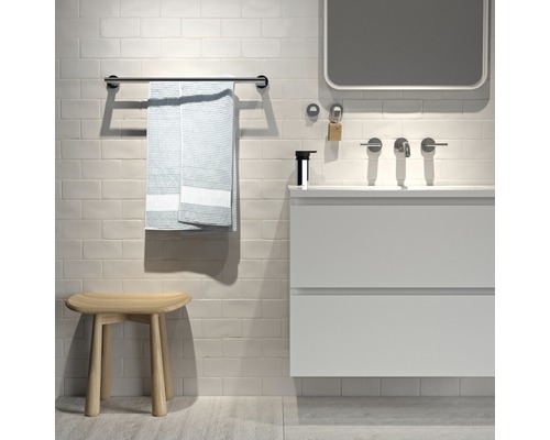 Modernes Badezimmer mit Waschtisch, Spiegel, Handtuchhalter, Handtuch und Hocker.