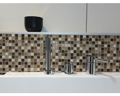 Badewannenarmatur mit Handbrause vor Mosaikfliesen