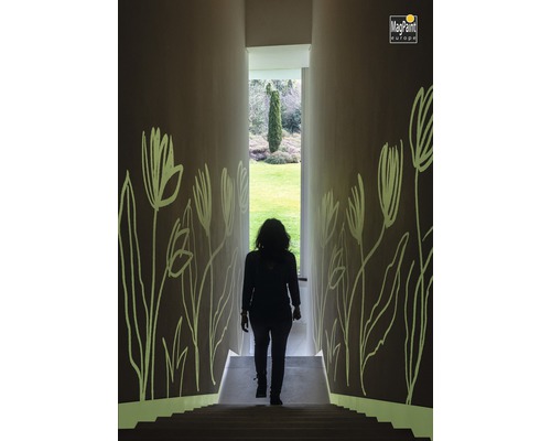Frau geht Treppe in einem Flur mit Blumenmustern an den Wänden hinunter. MagPaint Europe Logo.