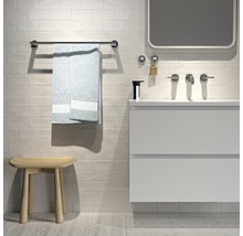 Badezimmeransicht mit Waschtisch, Spiegel, Handtuchhalter mit Handtuch und Hocker