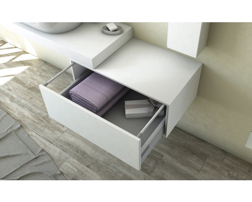 Weißer Waschtischunterschrank mit offener Schublade, gefüllt mit Handtüchern und einer Geschenkbox