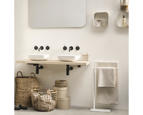 Badezimmer mit Doppelwaschbecken, Holztischplatte und Handtuchhalter.