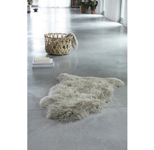 Heller Raum mit Schaffellteppich, Stapel Büchern und Korb