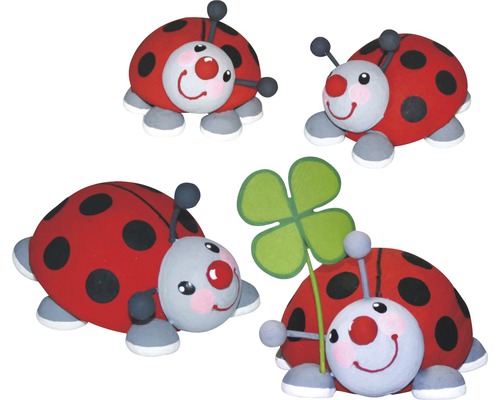 Dekorative Marienkäferfiguren, eine hält ein vierblättriges Kleeblatt