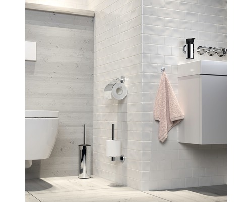 Modernes Badezimmer mit Toilette, Waschbecken, Armatur, Toilettenpapierhalter und Bürstengarnitur.
