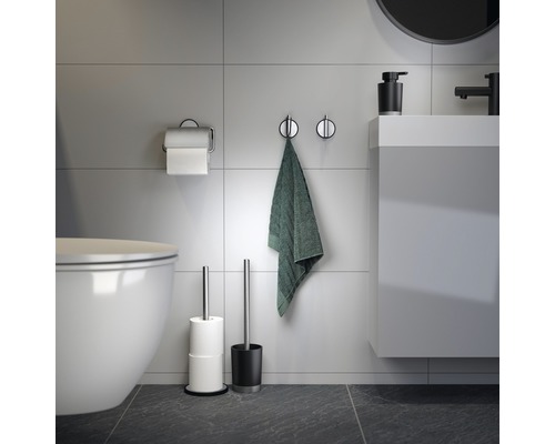 Modernes Badezimmer mit Toilette, Waschtisch, Handtuchhaken, Handtuch, Toilettenpapierhalter und WC-Bürste