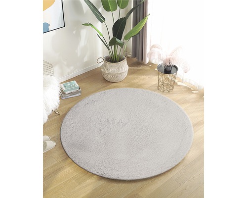 Einrichten mit rundem Teppich aus Kunstfaser auf Holzboden in einem hellen Raum.