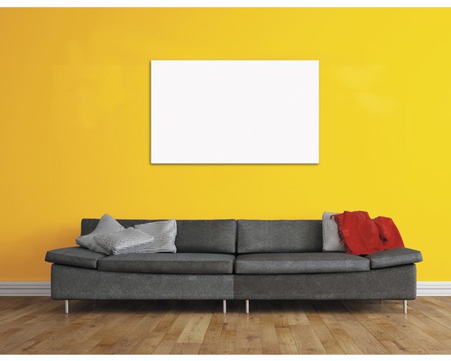 Wohnzimmer mit Sofa, Kissen und einem leeren Bild an der Wand