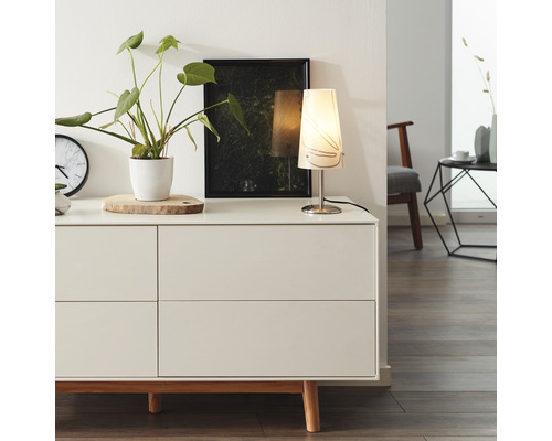 Kommode mit Zimmerpflanze, Uhr, Lampe und Bild