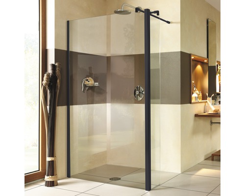 Ebenerdige Dusche mit Glaswand und dunklem Rahmen in einem Badezimmer.