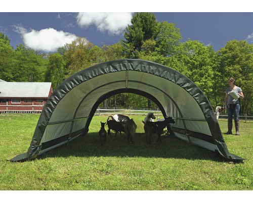 Tragbarer Unterstand für Tiere auf einer Weide mit Ziegen und einer Person