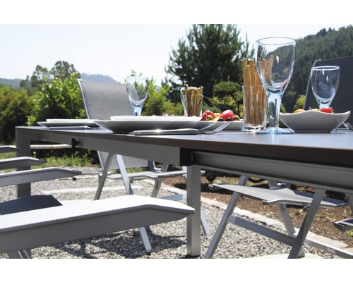 Gedeckter Gartentisch mit Stühlen im Freien