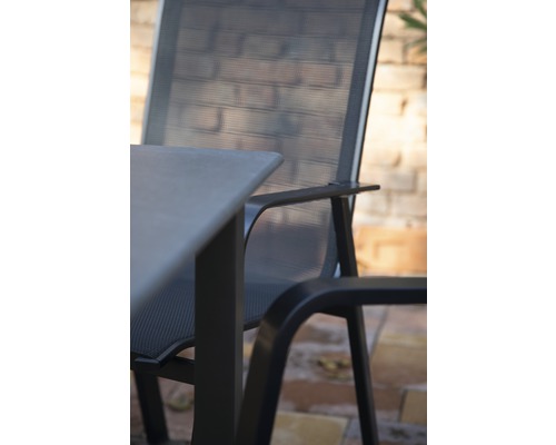 Detailaufnahme eines Gartentisches mit Stuhl aus Metall und Textilgewebe