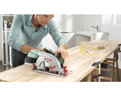 Mann sägt Holzplatte mit einer Bosch Handkreissäge