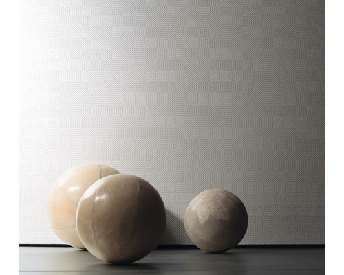 Nahaufnahme von drei Zierkugeln vor einer strukturierten Wand