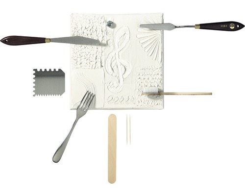 Verschiedene Modellierwerkzeuge und eine Reliefplatte mit Notenschlüssel