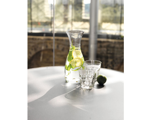 Wasserkaraffe mit Zitrone und Minze neben zwei Gläsern auf einem Tisch