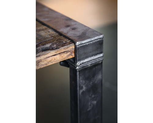 Detailansicht eines Tisches mit Holzplatte und Metallbeinen
