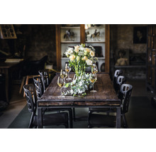 Esstisch aus Holz und Metall mit Stühlen, Blumenvase und Weingläsern