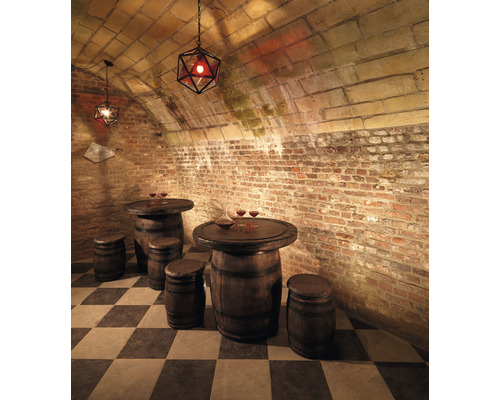 Kellerbar mit Tischen und Hockern aus Holzfässern, ergänzt durch geometrische Hängeleuchten.