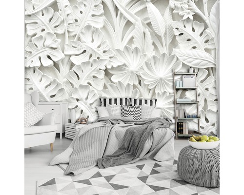 Schlafzimmer mit Bett, Nachttisch, Sessel und Wandtapete mit floralem Muster