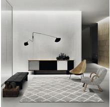 Wohnzimmer mit Sideboard, Teppich, Sesseln und Wandleuchte