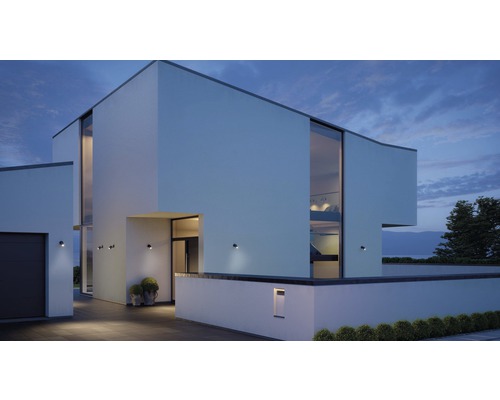 Modernes Haus mit Außenbeleuchtung und großen Fenstern bei Dämmerung