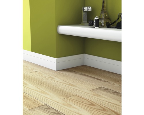 Innenaufnahme eines Zimmers mit Laminatboden, weißen Fußleisten und einem weißen Wandregal