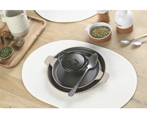 Tischgedeck mit Platzdeckchen, Teller, Schüssel und Löffel.