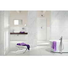 Helles Badezimmer mit Marmorfliesen, Badewanne und Waschtisch