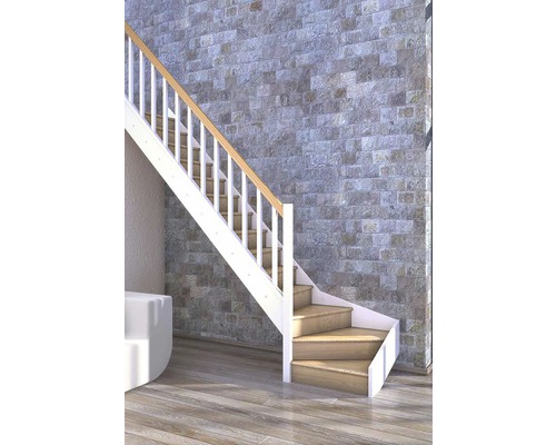 Treppe mit Holzstufen und weißem Geländer vor Steinwand