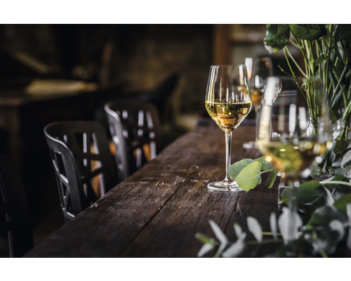 Szene mit gedecktem Holztisch, Weingläsern und Stühlen